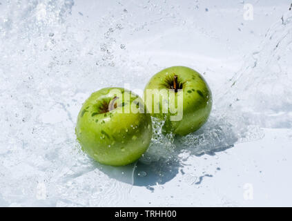 Two green apples in water splash on white background Stock Photo