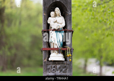 Statue of holy virgin mary (heilige Jungfrau Maria) / Madonna holding her child Jesus in her arms. The inscription below the statue reads 1842. Stock Photo