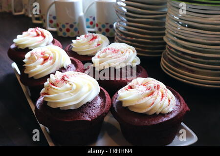 red velvet cakes with white frosting on a plate in a cafe setting Stock Photo