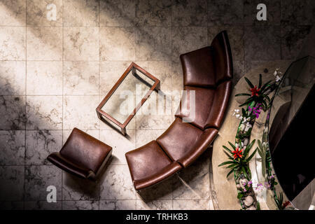 Brown leather chairs in hotel lobby with sunlight reflection Stock Photo