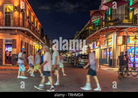 Night falls at Bourbon Street. Group of revellers enjoy a night out in the French Quarter Stock Photo