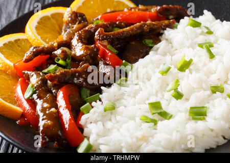Beef with sweet peppers in orange glaze served with rice close-up on a plate. horizontal Stock Photo