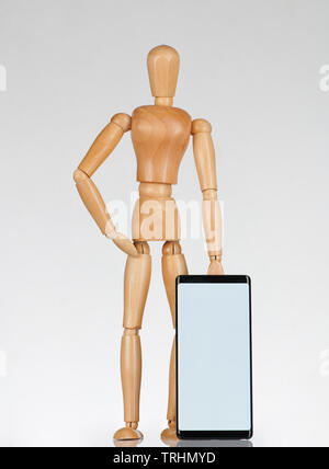 Wooden man with smartphone stand isolated on white background Stock Photo