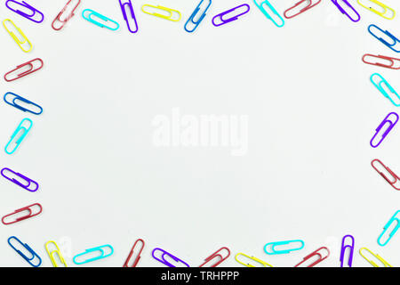Multicolored paper clips on white background with space for text. Stock Photo