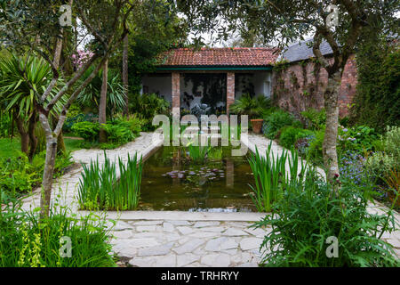 Formal lily pond  with paved surround and planting in teh Italian Garden at the Lost Gardens of Heligan, Cornwall, UK Stock Photo