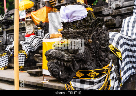 Balinese Hindu temple decorated for traditional festival. Stone dragons dressed for Balinese Hindu festival Stock Photo