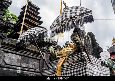 Balinese Hindu temple decorated for traditional festival. Stone dragons dressed for Balinese Hindu festival Stock Photo