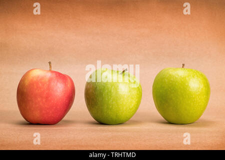 Three apples, two green and one red, on craft paper background with copy space Stock Photo