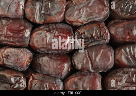 Dried dates arranged in rows. View from above. Food background Stock Photo