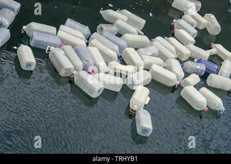 Empty large plastic containers, water cans floating in a bay in the Atlantic, waste, garbage disposal in the ocean, environmental pollution and plasti Stock Photo