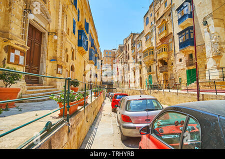 VALLETTA, MALTA - JUNE 19, 2018: The stone Lvant street with lines of living buildings, stretching along the narrow road, on June 19 in Valletta. Stock Photo