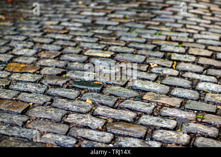 Stone pavement texture. Granite cobblestoned pavement background.  Cobbled stone road regular shapes, abstract background of old cobblestone pavement Stock Photo