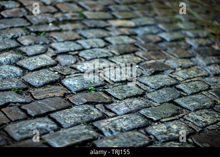 Stone pavement texture. Granite cobblestoned pavement background.  Cobbled stone road regular shapes, abstract background of old cobblestone pavement Stock Photo