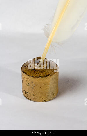 An old Feather quill in antique inkwell on a white background Stock Photo