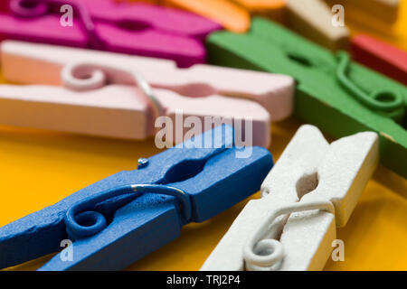 colored clothespins on a yellow background Stock Photo