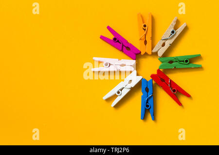 colored clothespins on a yellow background Stock Photo