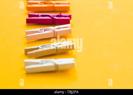 colored clothespins on a yellow background Stock Photo
