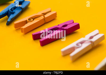 colored clothespins on a yellow background Stock Photo