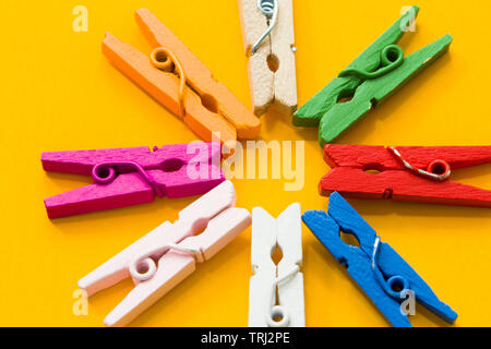 colored clothespins on a yellow background Stock Photo