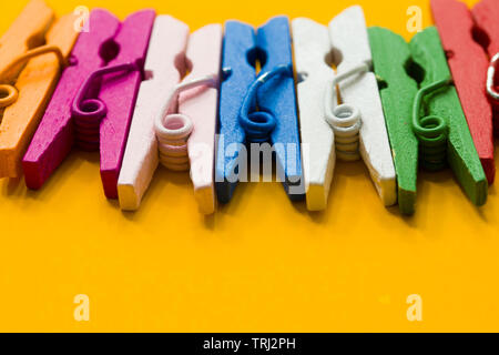 colored clothespins on a yellow background Stock Photo