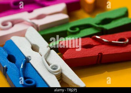 colored clothespins on a yellow background Stock Photo