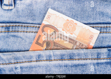 Money in pocket of blue pants. Finance and banking concept Stock Photo