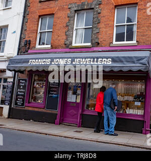 North Walsham, Norfolk, UK. 18 May 2019. Candid street photos – An older couple, lady in an orange coat and man in a blue coat looking in window of jewelry shop in North Walsham, Norfolk Stock Photo