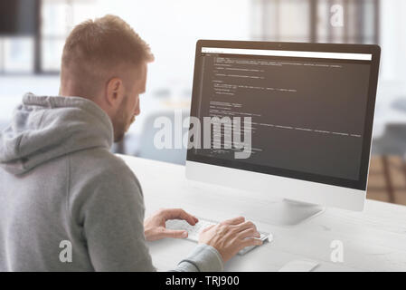 The guy programming on a computer in the office. Stock Photo