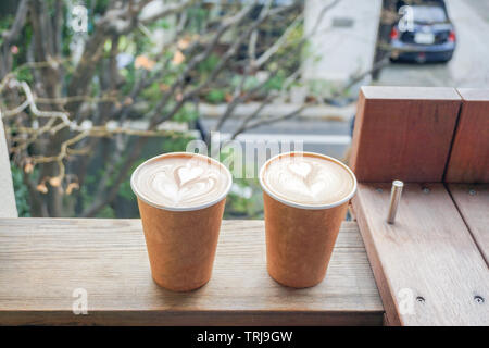 Hot coffee heart shape in paper cup on table terrace Stock Photo