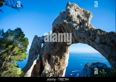 Scenic afternoon view through the Arco Naturale natural stone arch in the dramatic landscape of the Mediterranean island of Capri, Italy Stock Photo
