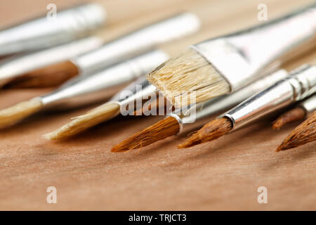 Extreme close up of a set of new art paint brushes on a wooden palette. Selective focus, shallow depth of field