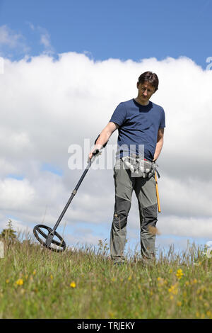A man searching for buried treasure, ancient coins and historic artefacts with metal detector Stock Photo