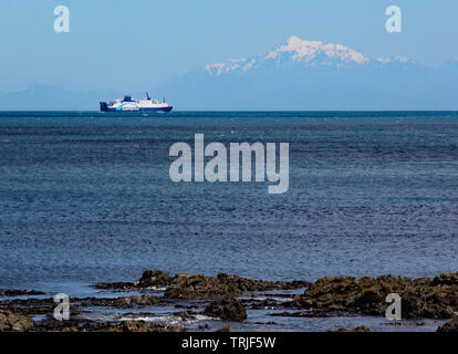 Interislander ferry on the Cook Strait sails towards the South Island. The snow capped mountains can be seen in the background Stock Photo