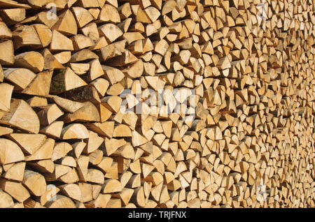Freshly cut and stacked wood logs. Wooden abstract background. Renewable energy Stock Photo