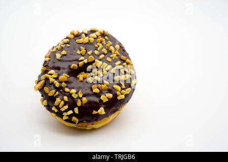 chocolate donut covered in chopped peanuts on an isolated white background Stock Photo