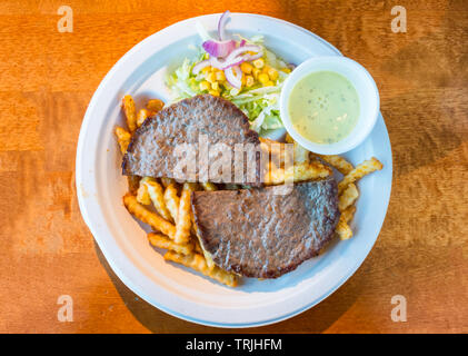Minced beef grilled sliced with potato, vegetable and sauce on paper plate Stock Photo