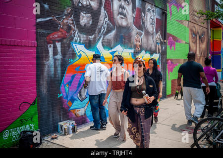 Thousands pour into Bushwick, Brooklyn in New York for the annual Bushwick Collective Block Party on Saturday, June 1, 2019. Music and partying brought some but the real attraction was the new murals  by 'graffiti' artists that decorate the walls of the buildings that the collective uses.  (© Richard B. Levine) Stock Photo