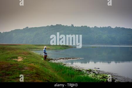 Padapuzha Ithikkunnu, East Kallada, Kollam, Kerala, India - May 17, 2019: Man fishing with fishing-hook in morning captured from Ithikkunnu, Padapuzha Stock Photo