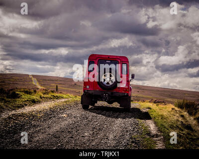 Red Land Rover Defender 110 4WD car navigating a Green Lane track, North Yorkshire Moors, UK. Stock Photo