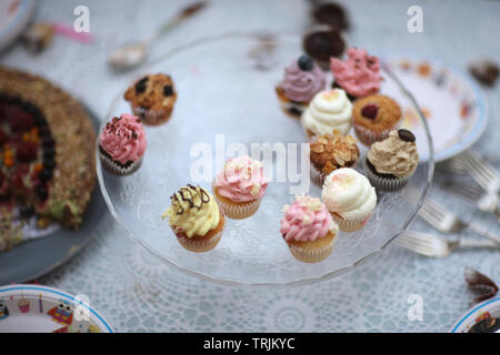 Colorful cupcakes in a vase on a table with cutlery after the children's holiday Stock Photo