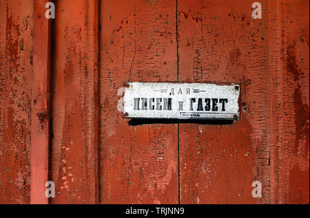 Texture of old wooden door with a hole and a sign for the mail Stock Photo