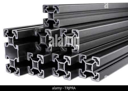 stack of black anodized aluminum extrusion bars, isolated on white background. Construction metal steel factory concept. Stock Photo