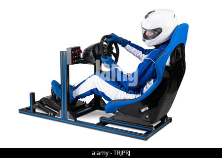 race driver in blue overall with helmet taining on simracing aluminum simulator rig for video game racing. Motorsport car bucket seat steering wheel p Stock Photo