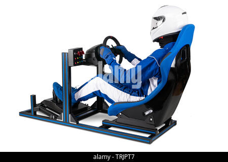 race driver in blue overall with helmet taining on simracing aluminum simulator rig for video game racing. Motorsport car bucket seat steering wheel p Stock Photo