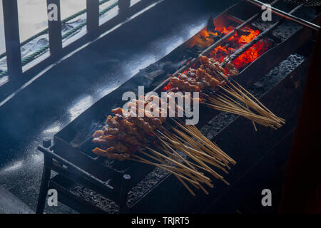 Chicken satay grill at a busy street food market Stock Photo