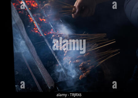 Chicken satay grill at a busy street food market Stock Photo