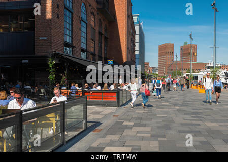 Oslo Aker Brygge, view of people relaxing on a summer afternoon on the Stranden - a waterfront promenade in the Aker Brygge harbour area of Oslo. Stock Photo