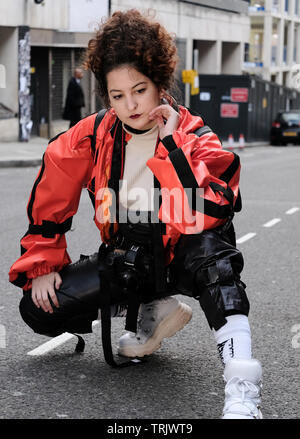 A guest at London Fashion Week posing outside Freemason's Hall for waiting photographers. Stock Photo
