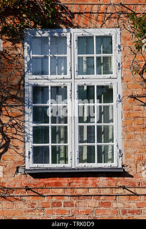 Closed window in red old brick wall. Stock Photo