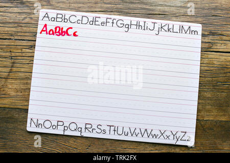 Top view of a white penmanship board with the letters ABC written in red marker by a child Stock Photo